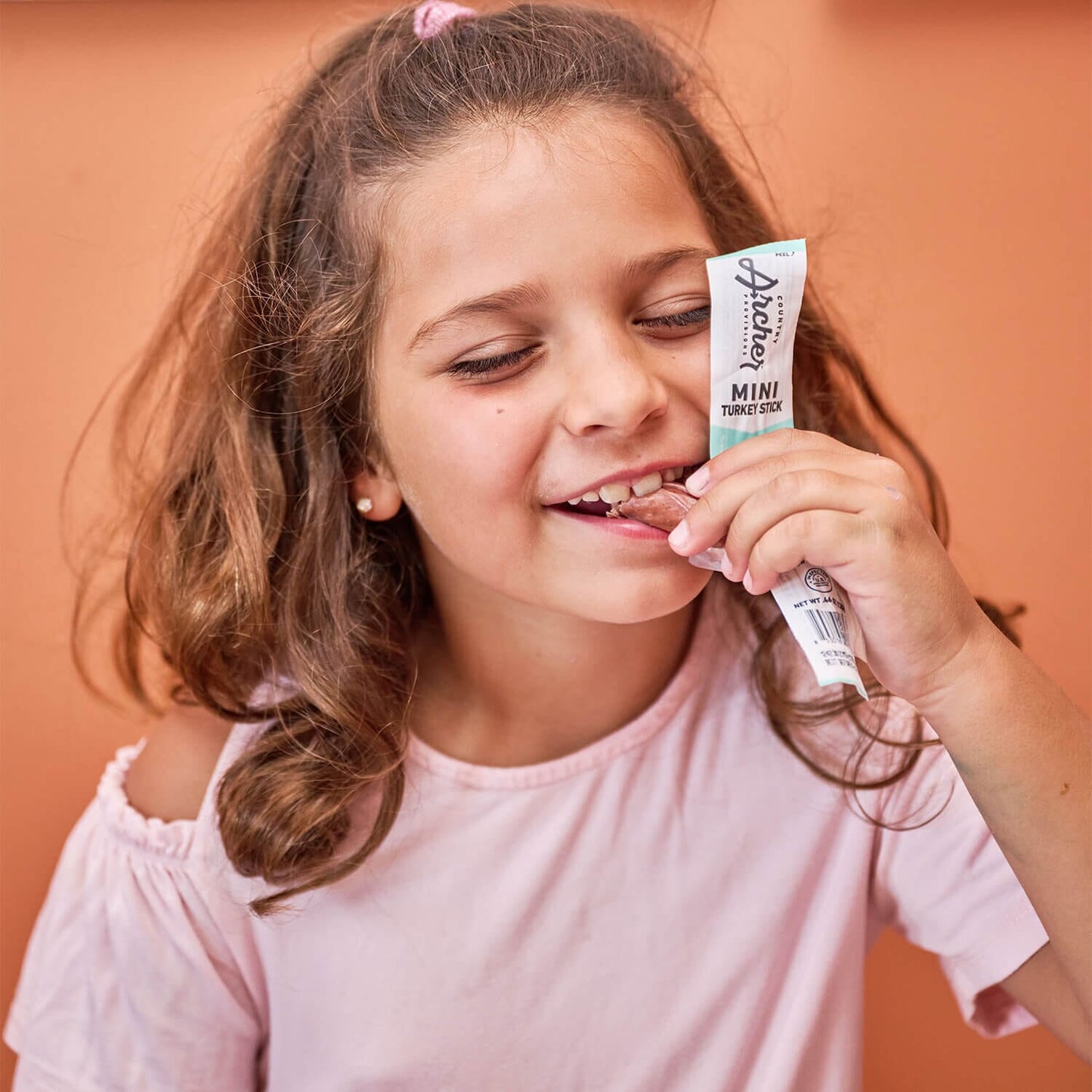 Young girl eating turkey mini stick